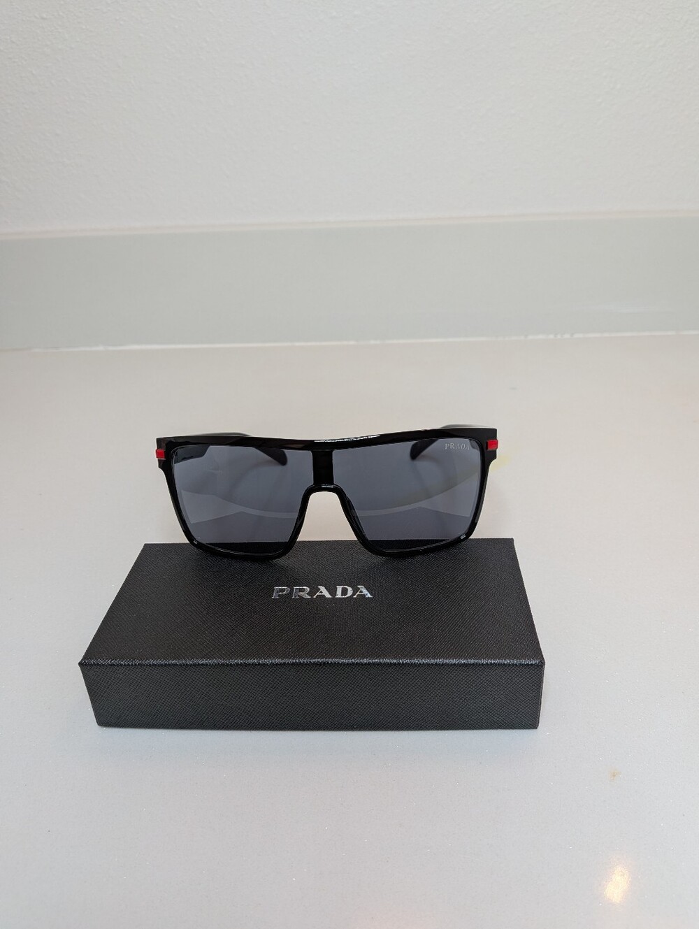Prada Men's Black Shield Sunglasses Red Logo